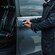 A person opening a sliding van door and gesturing to enter